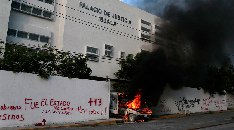 Un vehículo quemándose en la entrada del Palacio de Justicia, durante una protesta para exigir justicia por los 43 desaparecidos de Ayotzinapa. Foto: EFE