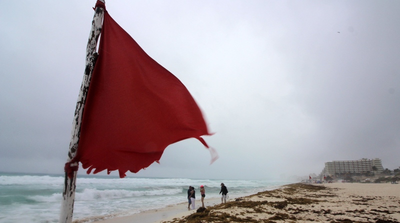 Una alerta de marea agitada se previene mediante banderas, en la playa de Cancún, en el estado de Quintana Roo, en México. Foto: EFE.