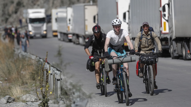 Algunos rusos prefieren usar transportes alternativos en su viaje, como bicicletas, ante los atascos de tráfico que se forman en la frontera. Fotos: EFE / EPA.