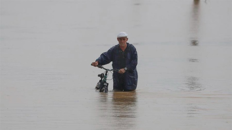 Un hombre cruza con su bicicleta una calle inundada debido a lluvias por el paso del huracán Fiona en Toa Baja (Puerto Rico). Foto: EFE