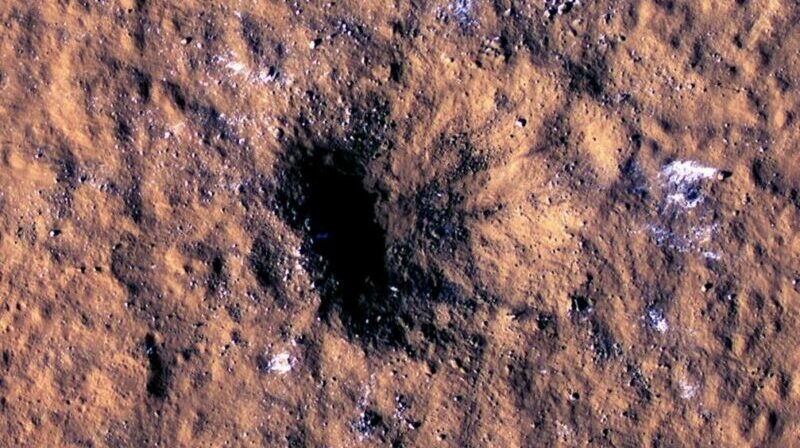 Se pueden ver bloques de hielo de agua del tamaño de una roca alrededor del borde de un cráter de impacto en Marte, vistos por el Experimento científico de imágenes de alta resolución (cámara HiRISE) a bordo del Mars Reconnaissance Orbiter de la NASA. Foto: Europa Press.