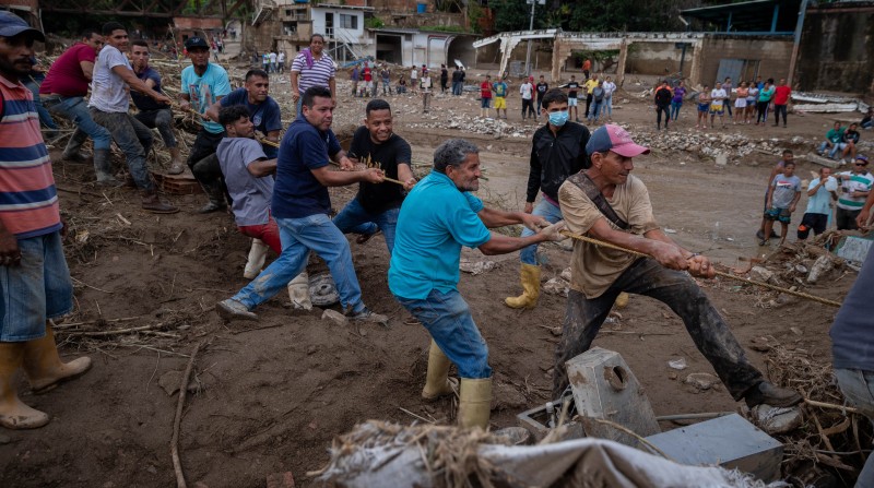 Habitantes colaboran en las tareas de limpieza tras el desbordamiento de la quebrada Los Patos, en Las Tejerías, Venezuela. Foto: EFE.