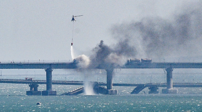 Un helicóptero de bomberos vierte agua sobre una parte derrumbada del puente del Estrecho de Kerch en Crimea este 8 de octubre de 2022. Foto: EFE / EPA / STRINGER