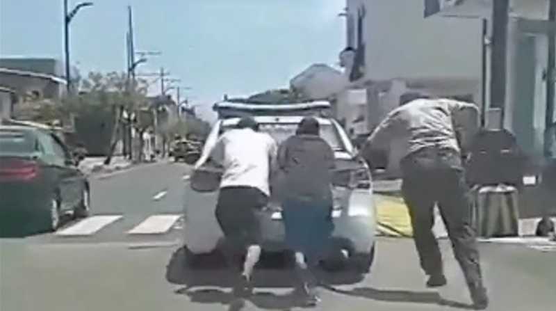 Tres personas empujan un patrullero y el video se vuelve viral. Foto: Captura de video