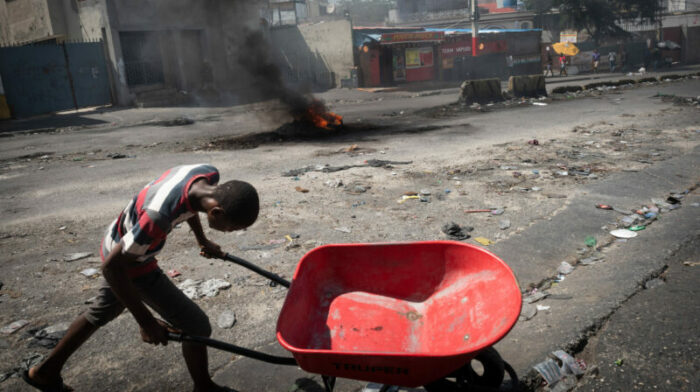 Un joven carga una carreta durante una protesta por la crisis económica y de seguridad, en Puerto Príncipe (Haití). Foto: EFE.
