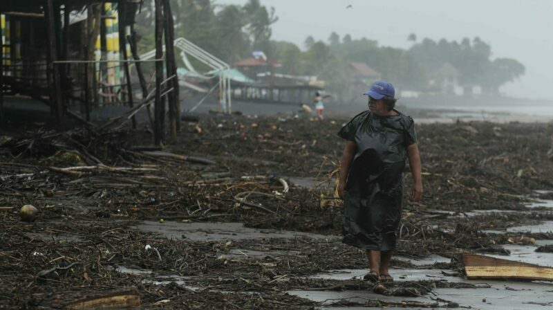 Una persona camina por una playa con destrozos tras el paso de la tormenta tropical Julia, en La Libertad (El Salvador). Foto: EFE.