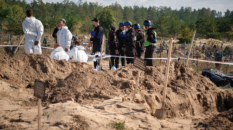 Técnicos forenses trabajan en un lugar de entierro cerca de la ciudad recientemente recuperada de Lyman, área de Donetsk, Ucrania, el 7 de octubre de 2022. Foto: EFE