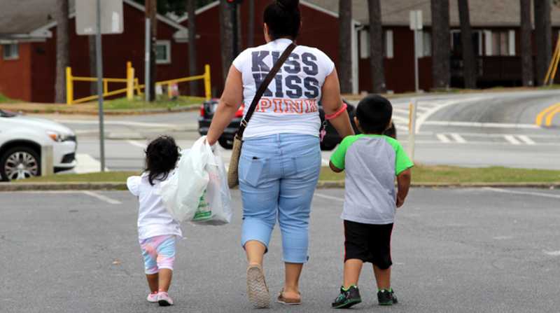 Una mujer camina con dos niños. Foto: EFE / Archivo