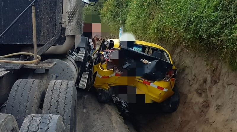 El taxi quedó aplastado contra la pared de un talud, luego del impacto con un tráiler en El Quinche. Foto: Cortesía MSP