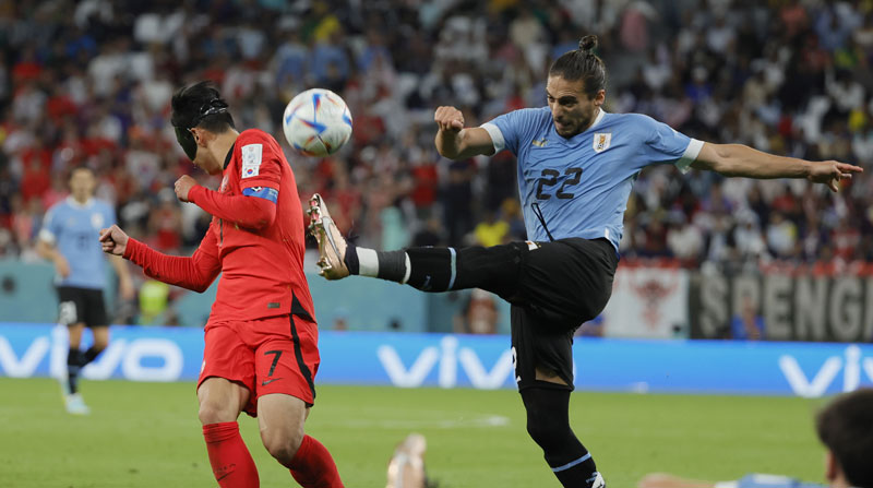 Martin Cáceres de Uruguay remata ante la marca de Heungmin Son de Corea del Sur en el Mundial Qatar 2022. Foto: EFE