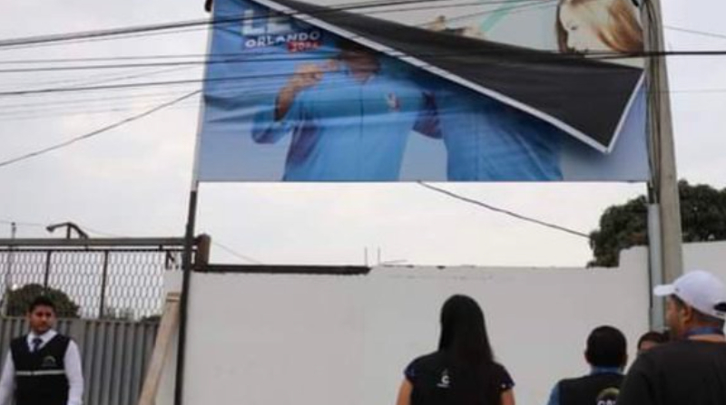 Miembros de la Delegación Provincial Electoral de Manabí retiran una valla publicitaria por realizar precampaña. Foto: Twitter Fernando Villavicencio
