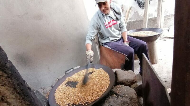 En Samanga, Giovanni Santana atiza el fuego con leña para tostar los granos de cebada que luego serán pasados por un molino. Foto: Modesto Moreta / EL COMERCIO.