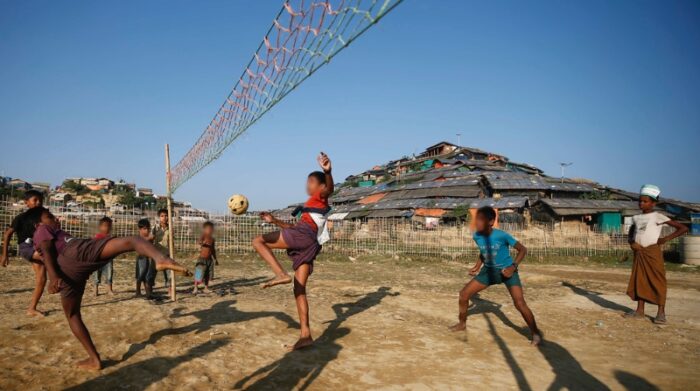 Niños refugiados rohingya juegan al fútbol con una pelota hecha de bambú en el campo de refugiados de Cox Bazaar, en Bangladesh. El personal de MSF es testigo del impacto que tienen las condiciones de los campos, congestionados e insalubres, en la salud física y mental de las personas refugiadas. Cada vez están recibiendo a una mayor cantidad de pacientes que necesitan tratamiento para infecciones de la piel, o de enfermedades transmitidas por el agua, y patologías crónicas como la diabetes y la hipertensión. Noviembre 2018. Foto: Vincenzo Livieri