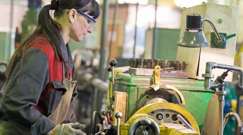 Una mujer es fotografiada en una fábrica de productos industriales. Por la labor, recibe menos compensación que sus pares hombres. Foto: EFE.