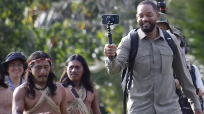 Will Smith en una fotografía compartida por Waorani Expeditions donde aparece con un celular junto a la comunidad. Foto: Woarani Expeditions Instagram