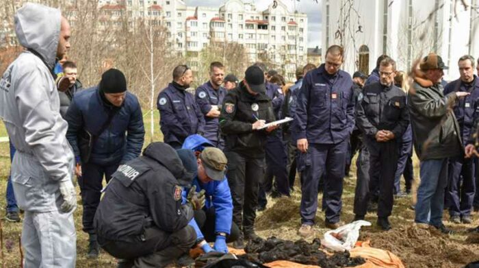 Miembros de un equipo internacional de fiscales de crímenes de guerra, durante una visita a una fosa común en Kiev, el 12 de abril de 2022. Foto: EFE/OLEG PETRASYUK