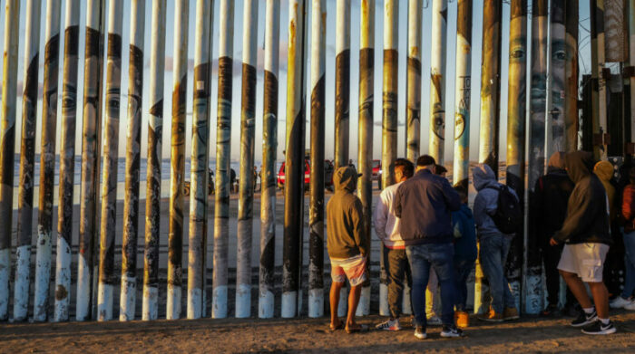 Un grupo de personas observan el rescate del cuerpo de un migrante de origen ruso, el 9 de noviembre de 2022 en la ciudad fronteriza de Tijuana, Baja California (México). Foto: EFE.