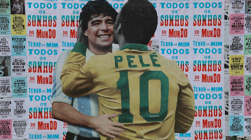Personas caminan frente a un mural con la imagen de Diego Maradona y Pelé, en la Avenida Paulista de Sao Paulo. Foto: EFE