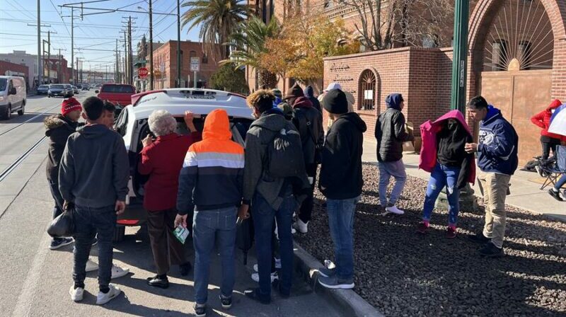 Inmigrantes reciben alimentos afuera de un refugio, en El Paso (Estados Unidos). Foto: EFE.