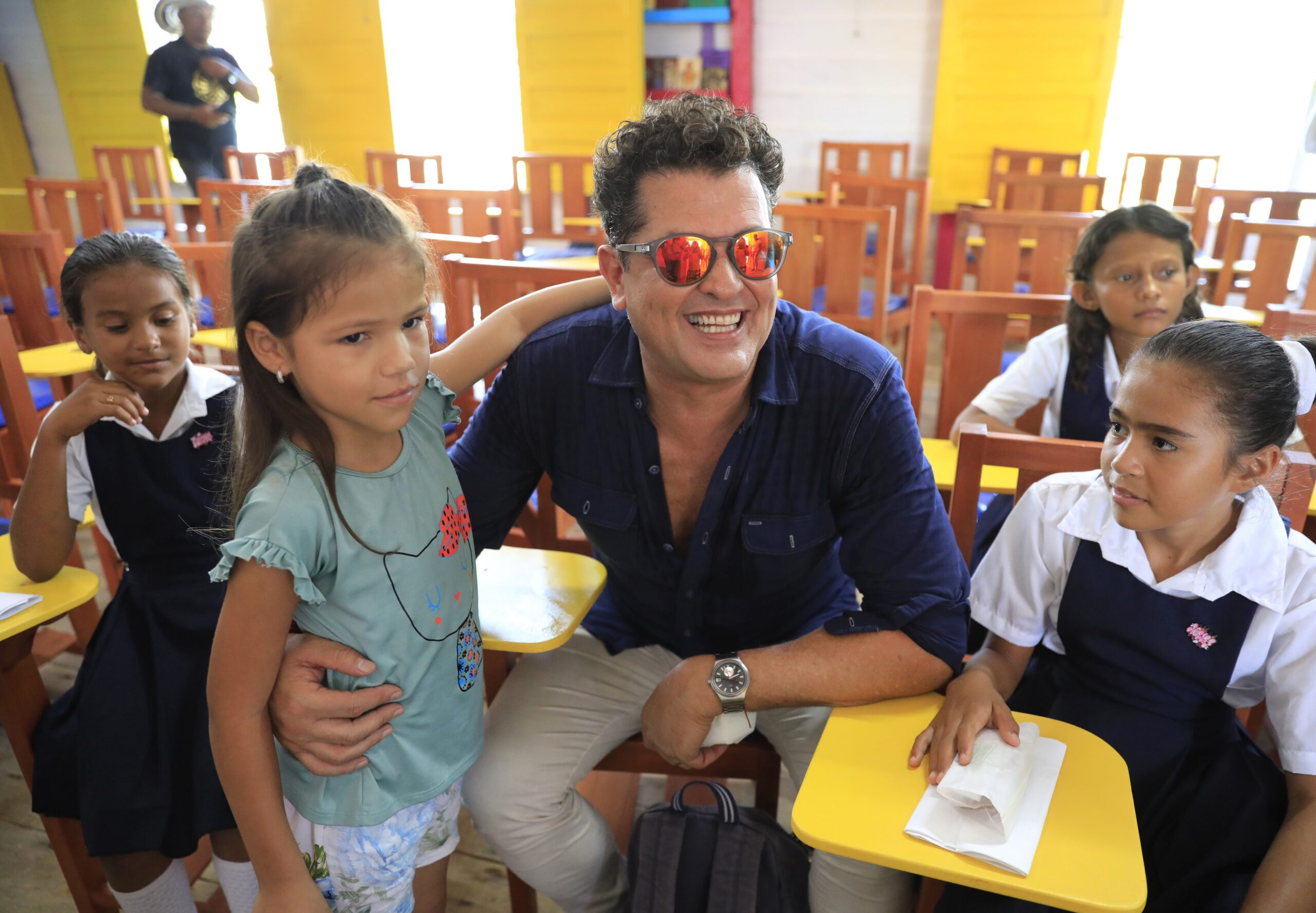 Carlos Vives saluda a un grupo de niños que fueron beneficiados del proyecto social-educativo que impulsó en esa zona. Foto: EFE.