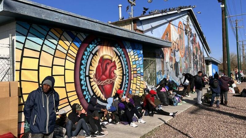 Decenas de inmigrantes llegados de México esperan para recibir ayuda y alimentos afuera de la iglesia Sagrado Corazón en El Paso, Texas (EE.UU.). Foto: EFE.