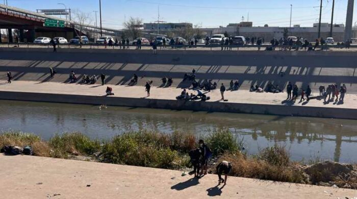Vista general desde la valla fronteriza de El Paso, Texas, donde se muestra a varios migrantes esperando para cruzar el río en la zona de Ciudad Juárez, México. Foto: EFE