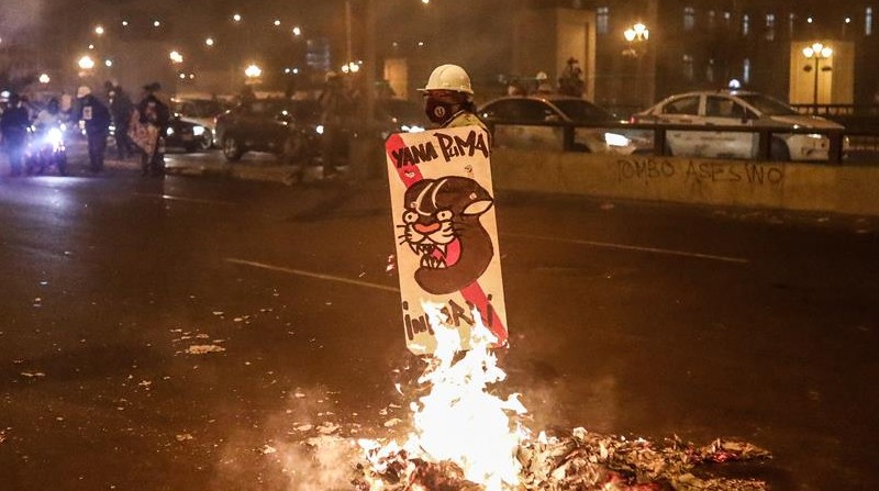 Un manifestante permanece junto a una barricada en llamas, durante una protesta en los exteriores de Palacio de Justicia en Lima (Perú), en una fotografía de archivo. Foto: EFE