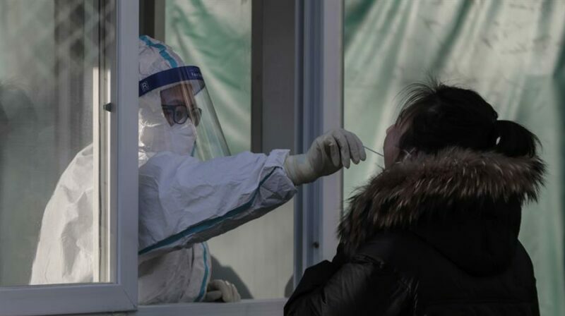 Un trabajador de la salud realiza una prueba para detectar la covid-19, en Pekín (China). Foto: EFE.