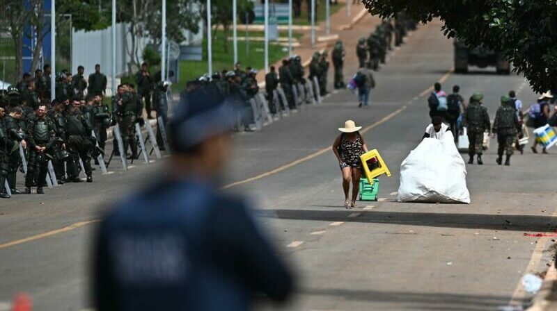 Seguidores del expresidente Jair Bolsonaro salen de las tiendas de campaña en un campamento. Foto: EFE.