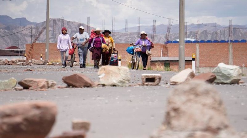 Fotografía de personas caminan que por una calle bloqueada, el pasado 17 de enero de 2023, en el lado peruano de la población de Desaguadero, en la frontera con Bolivia. Foto: EFE