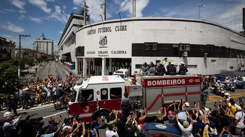 Un camión de bomberos que transporta el féretro con el cuerpo de la leyenda del fútbol Pelé encabeza el cortejo fúnebre que recorrió algunas calles de la ciudad de Santos. Foto: EFE