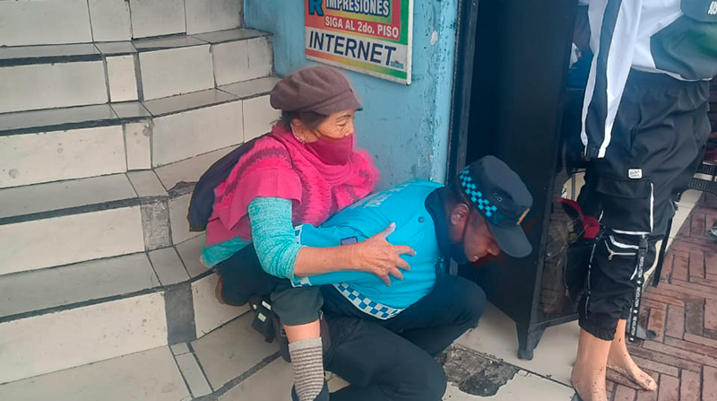 Momento en el que un agente de control carga a una mujer de la tercera edad. Foto: Agentes Control Quito