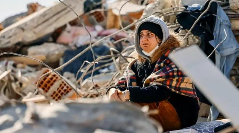 Una mujer junto a los escombros de un edificio, tras los terremotos de Turquía. Foto: EFE.