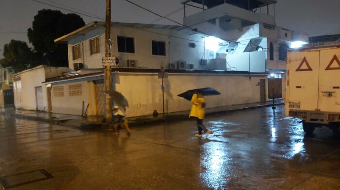 En la ciudadela Vernaza Norte la lluvia obligó a transeúntes a protegerse. Foto. Juan Carlos Holguín / EL COMERCIO