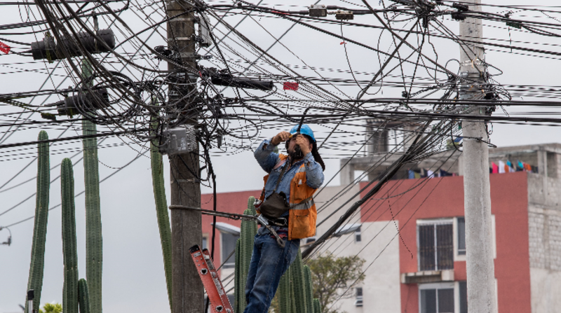 Un trabajador de CNT trabaja con los cables de un poste en la AV. Coruña y Julio Zaldumbide. Foto: Carlos Noriega / EL COMERCIO