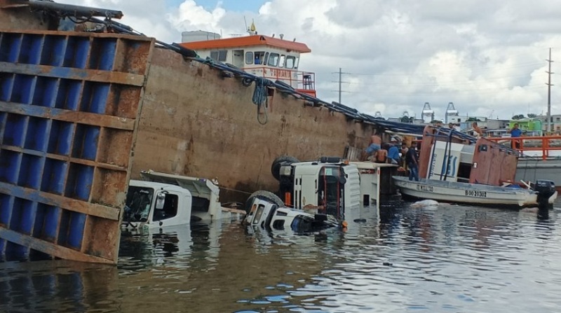Los camiones quedaron sumergidos en el estero cuando la gabarra se viró. Foto: Bomberos Guayaquil