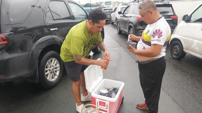 Tras quedar atrapado, Luis Andrade (i) comenzó a vender las humitas y bolones que llevaba para su negocio. Foto: Juan C. Holguín / EL COMERCIO