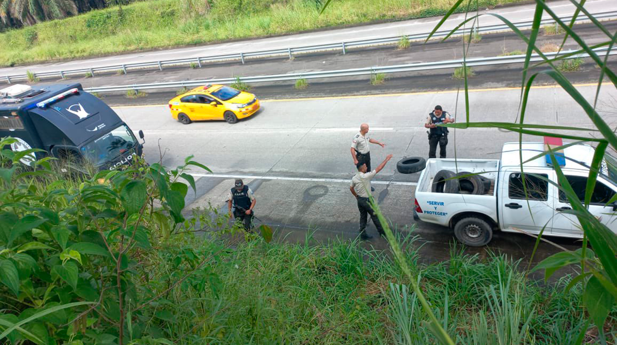 Momento en el que los policías retiran las llantas en la vía de Quevedo. Foto: Policía
