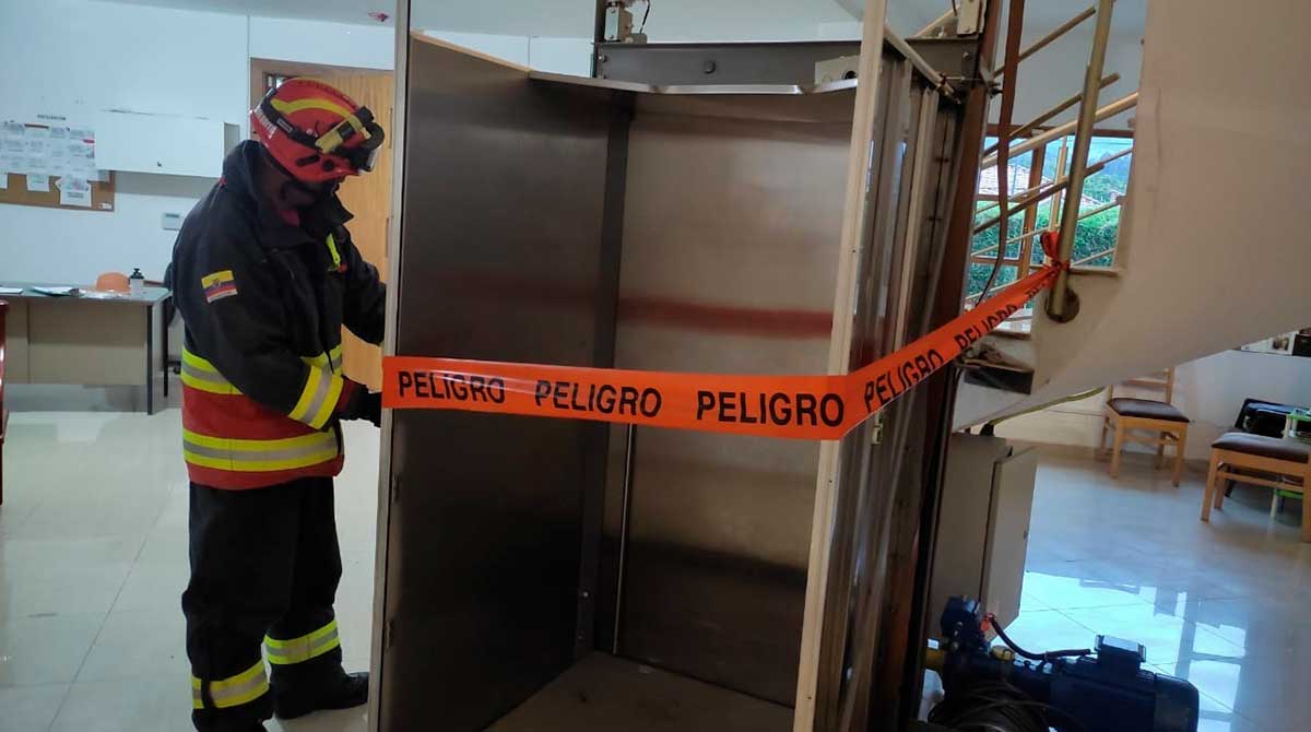 Un bombero coloca cinta de seguridad en el ascensor que sufrió un desperfecto. Foto: Bomberos Quito