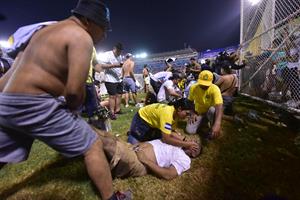 Fanáticos auxilian a personas durante una estampida en el Estadio Cuscatlán, en la tragedia de El Salvador. Foto: EFE