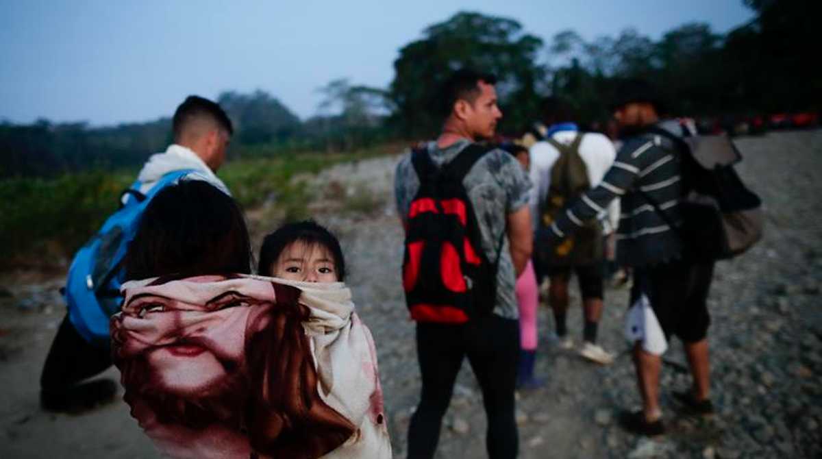 Adultos y niños migrantes hacen fila en la comunidad de Bajo Chiquito para ser trasladados a la Estación de Recepción Migratoria (ERM) de San Vicente, en Metetí (Panamá). Foto: EFE