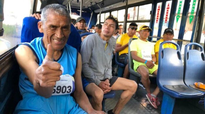 Ernesto Lincango (izq.) y otros atletas llegaron en bus al sector de San Bartolo para la partida de la Quito Últimas Noticias 15K. Foto: Carlos Rojas / EL COMERCIO
