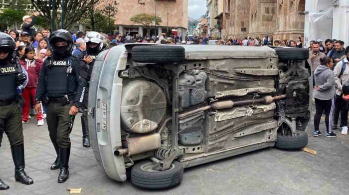 Ciudadanos intentaron quemar un vehículo donde, supuestamente, se transportaban dos sospechosos de robar a un hombre en el Centro Histórico de Cuenca. Foto: EL COMERCIO