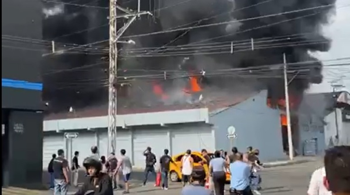Enormes lenguas de fuego salen de la bodega. El humo se divisa desde varias partes de la ciudad. Foto: Captura de video