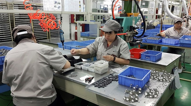Trabajadores ajustan chips y metales en una compañía en China. Foto: EFE