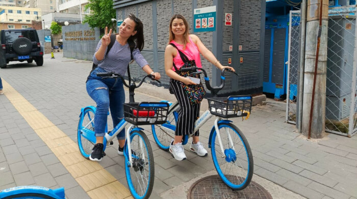 En China, Lisandra y Carolina, periodistas de Cuba y Colombia, en una bicicleta compartida. Foto: Paola Gavilanes/ EL COMERCIO