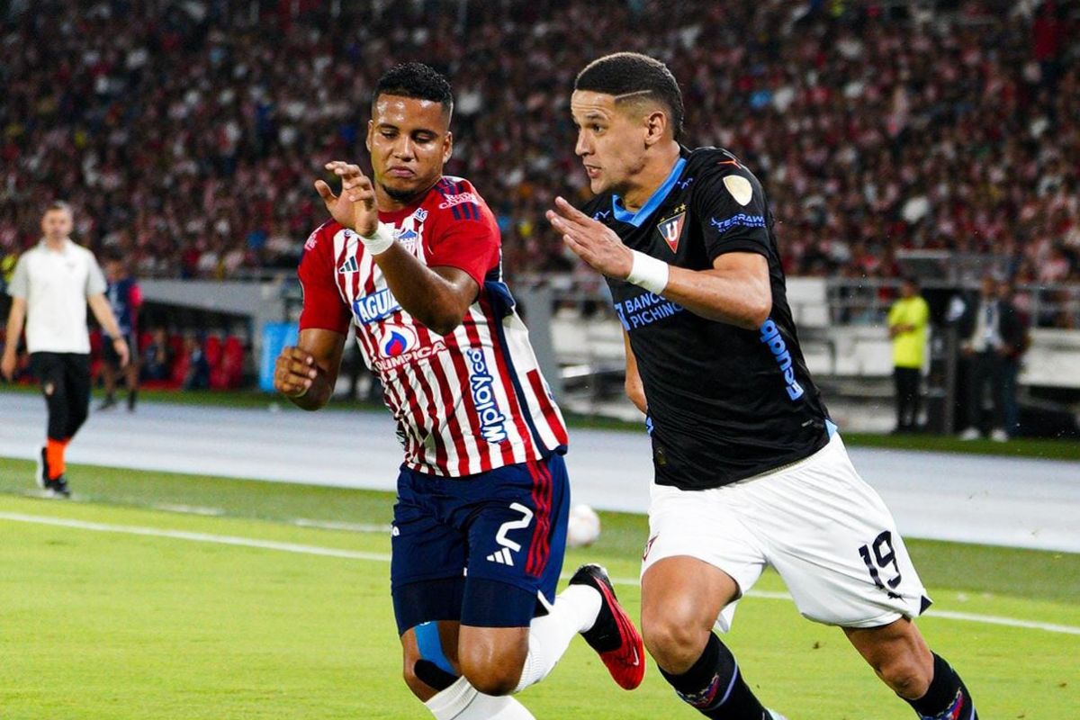 Álex Arce, delantero de Liga de Quito, disputa un balón con un rival de Junior de Barranquilla en la Copa Libertadores