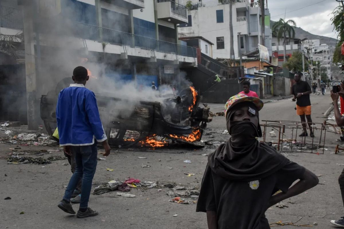Policías vigilan a personas que participan de una protesta en Puerto Príncipe (Haití), en una fotografía de archivo. Foto: Siffroy Clarens/EFE