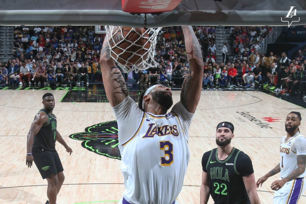 Anthony Davis, de Los Angeles Lakers, haciendo un mate ante la mirada de la estrella de los New Orleans Pelicans, Zion Williamson (izq.)