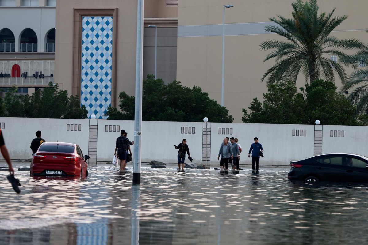 Peatones caminan cerca de carreteras inundadas después de fuertes lluvias en Dubai, Emiratos Árabes Unidos. Foto: Ali Haider/EFE